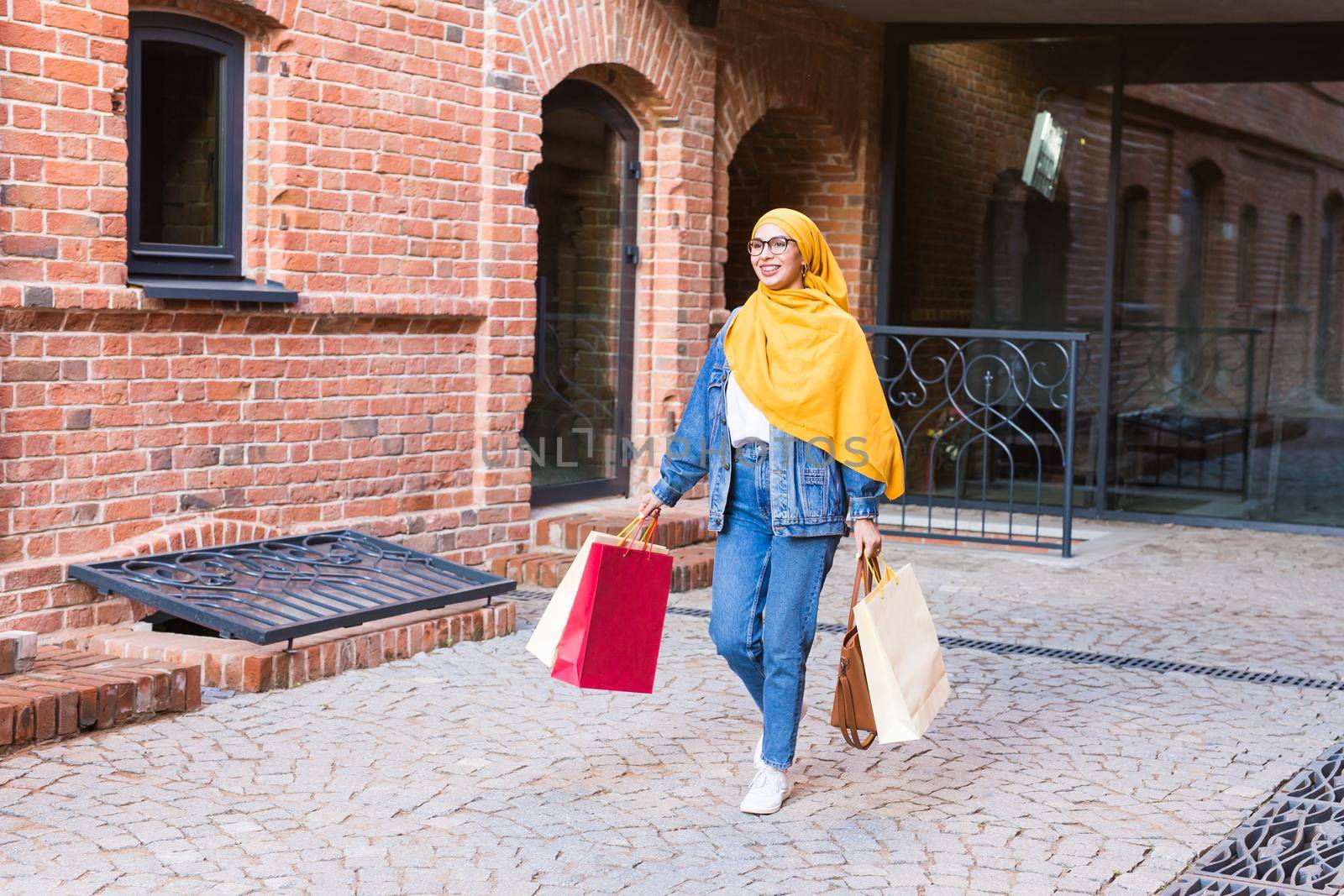 Sale and buying concept - Happy arab muslim girl with shopping bags after mall by Satura86