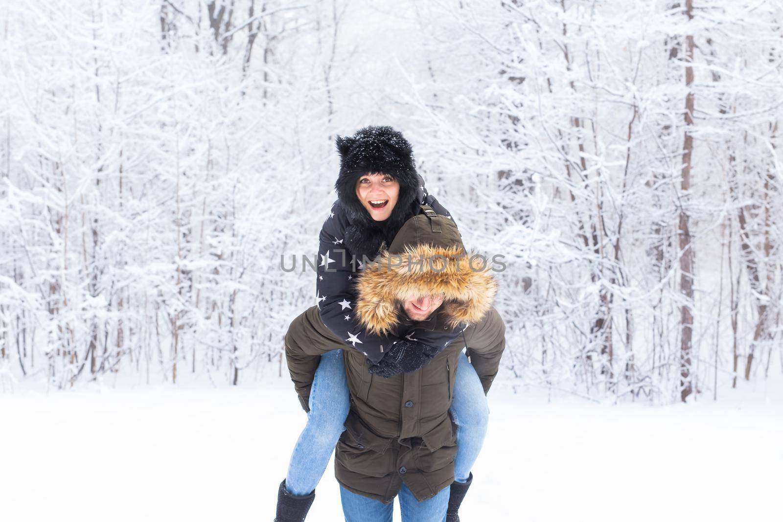 Portrait of happy young couple in winter park with their friend behind by Satura86