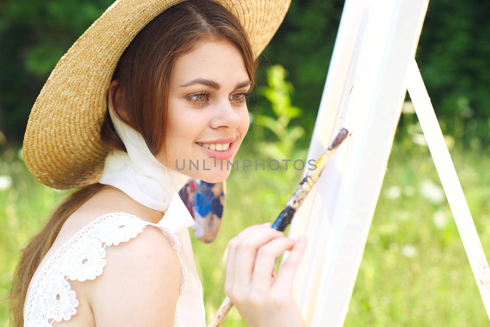 Woman in white dress artist paints on nature palette creative. High quality photo