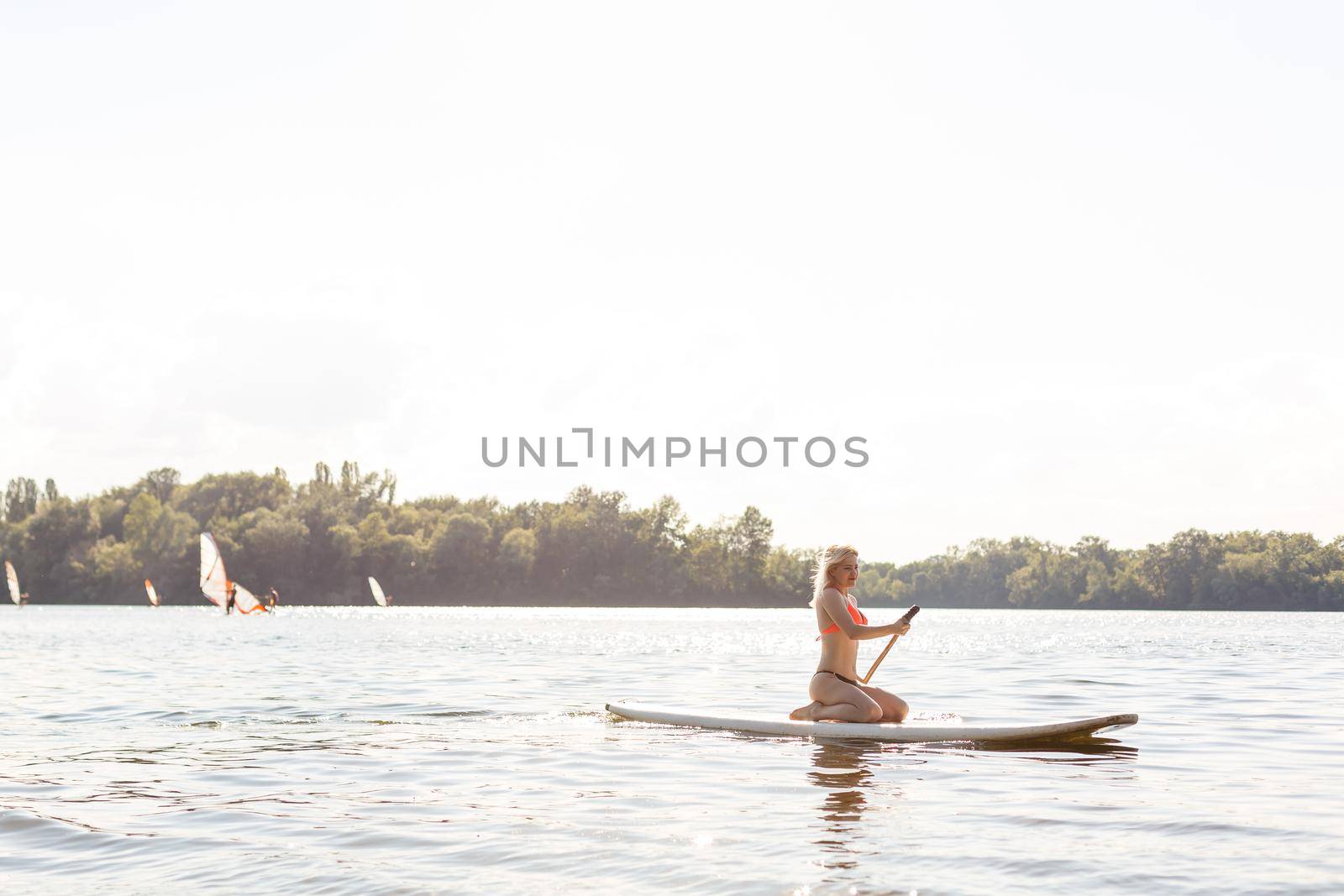 woman with a paddle on the blackboard. legs of a slender girl on stand up paddle board.