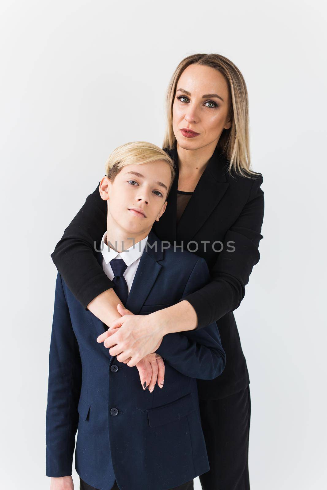 Teenager and single parent - Young mother and son standing together on white background. by Satura86
