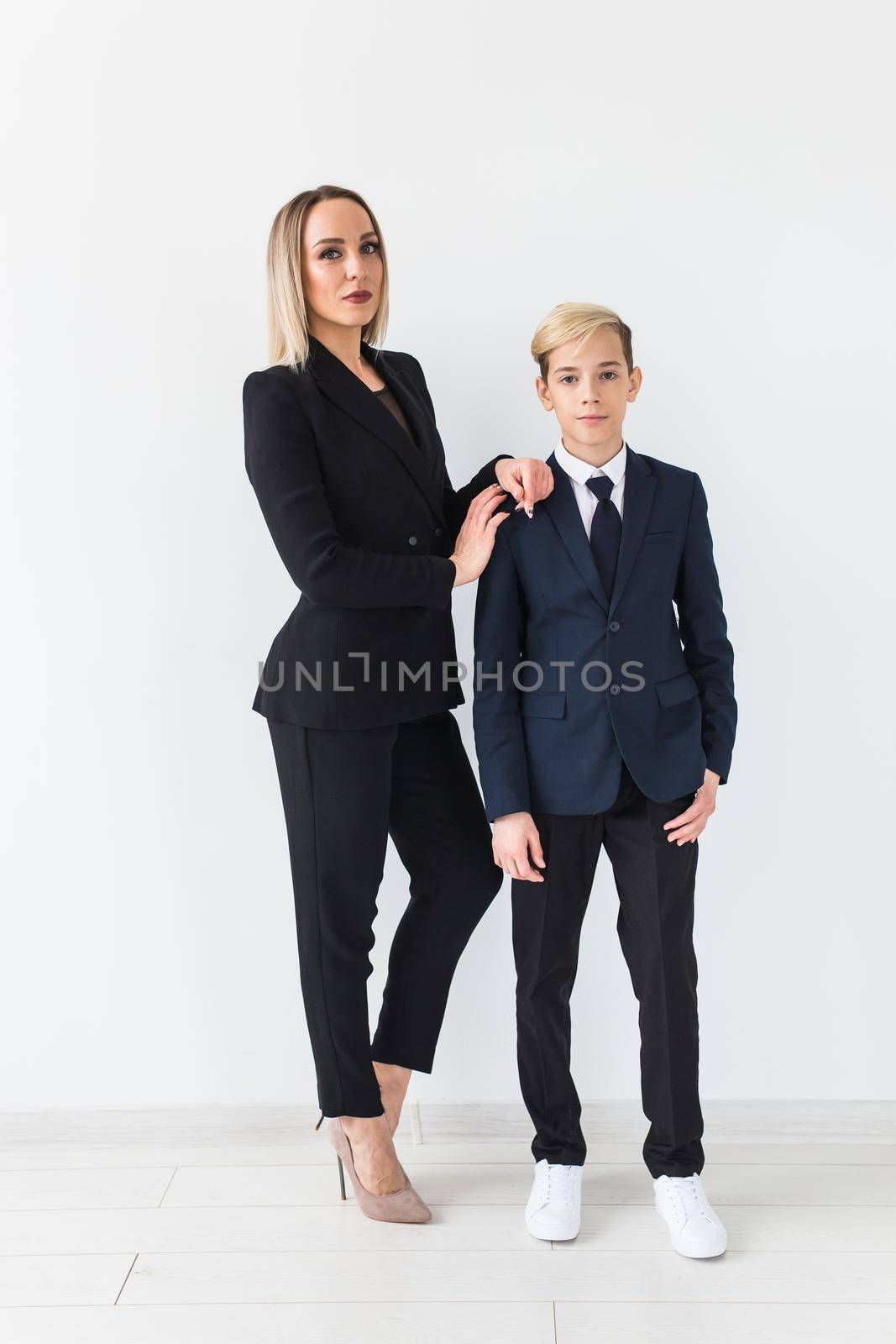 Parenting, family and single parent concept - A happy mother and teen son smiling on white.