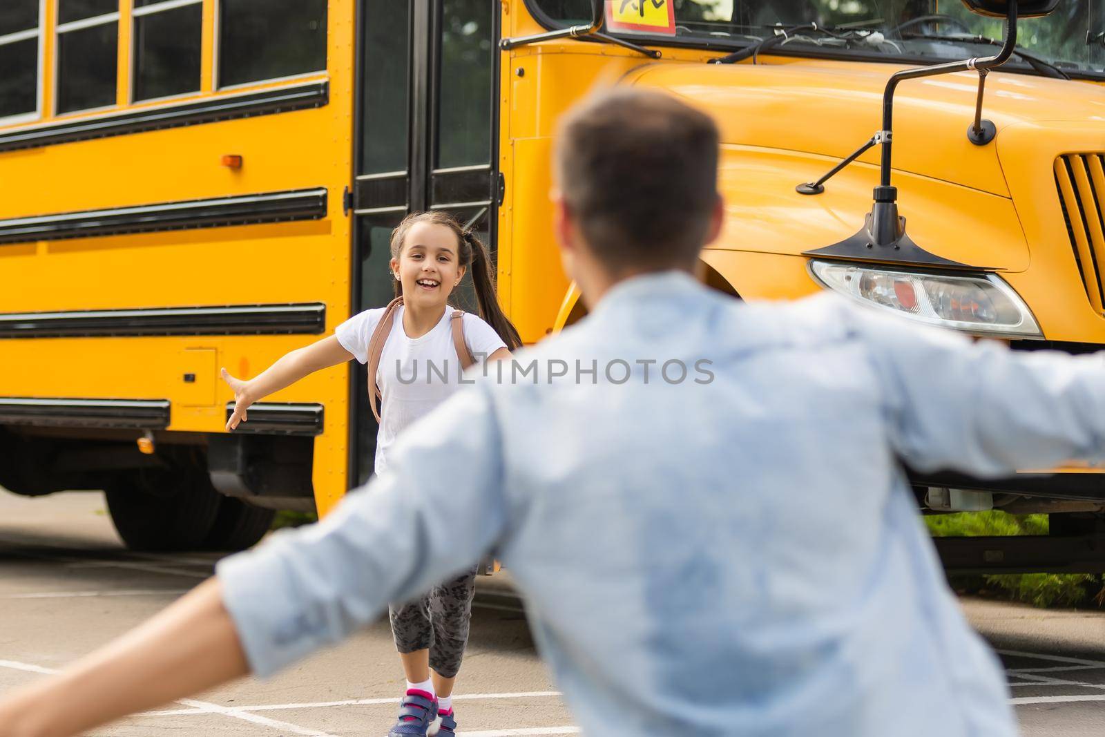 Father meeting little daughter coming out of school bus by Andelov13