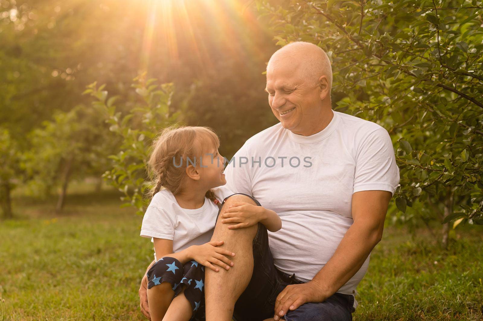 Little girl spending time with grandfather in the park.