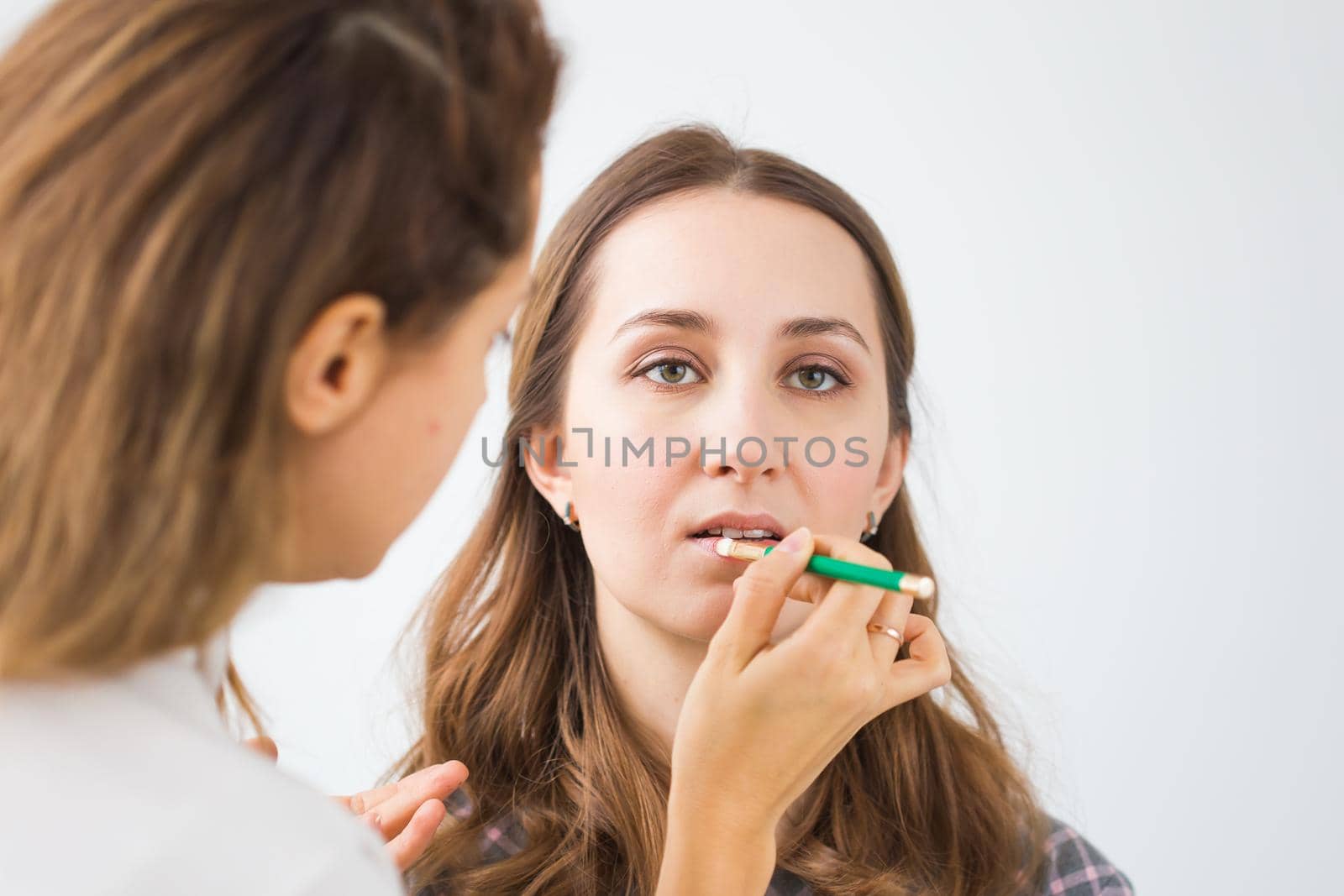 Beauty and cosmetics concept - Make-up artist doing professional make up of young woman by Satura86
