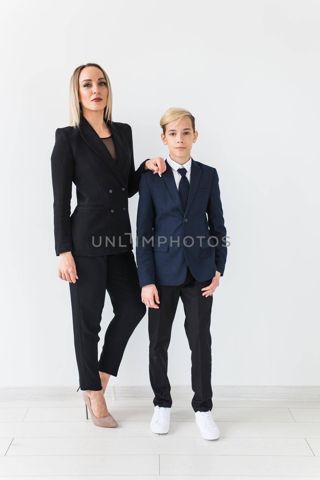 Teenager and single parent - Young mother and son standing together on white background. by Satura86