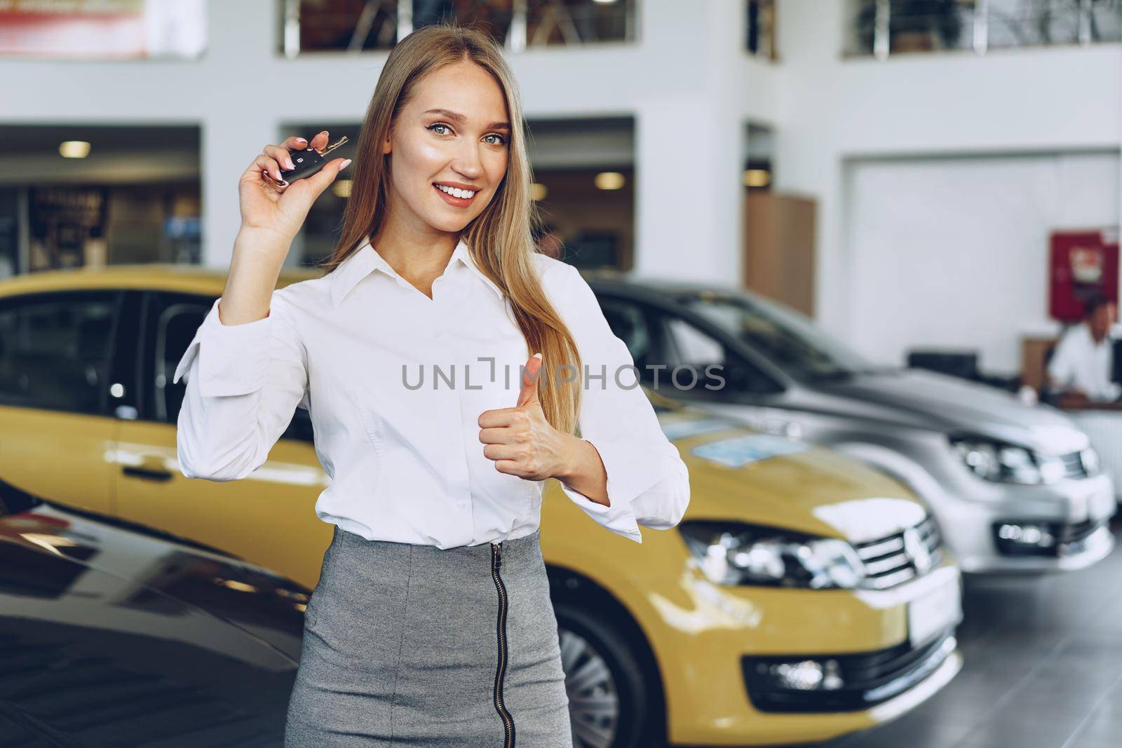 Young happy woman buyer/seller near the car with keys in hand close up