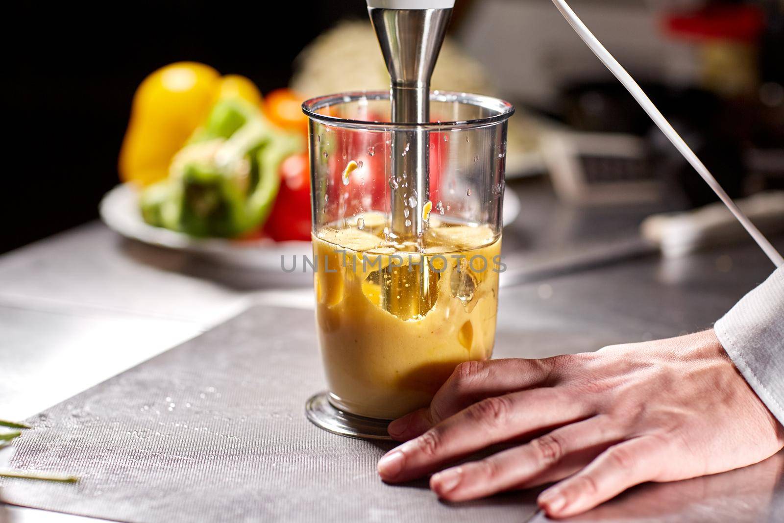 Beating of homemade mayonnaise with olive oil. Mix ingredients for sauce. The chef uses a blender. Step by step sauce preparation.
