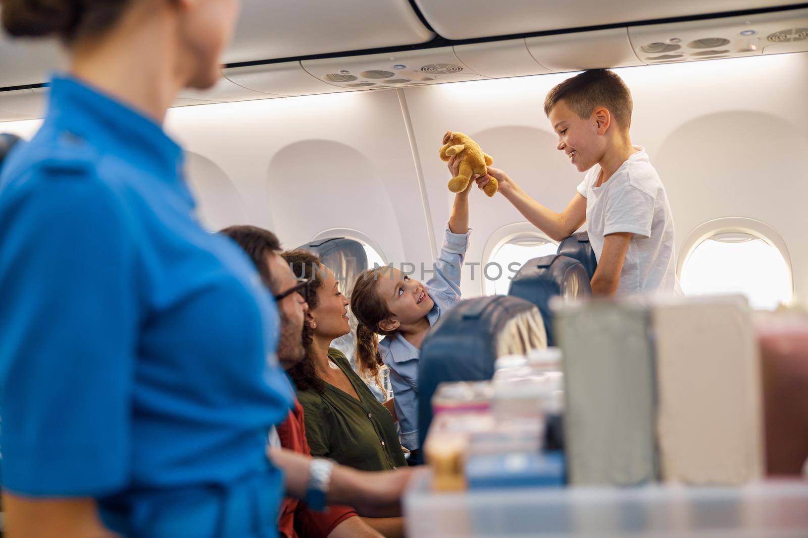 Two happy kids playing with a toy during flight. Family traveling together by plane by Yaroslav_astakhov