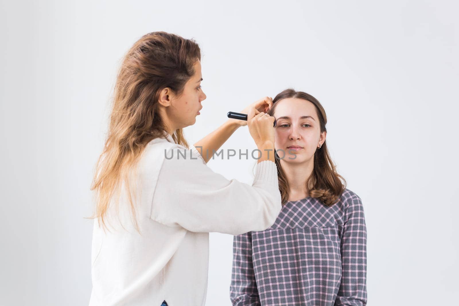 Beauty and cosmetics concept - Makeup artist doing professional make up of young woman by Satura86
