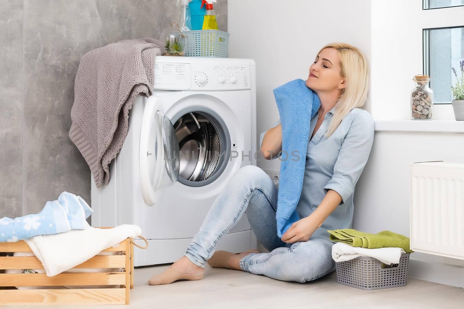 A young housewife with washing machine and clothes. Washing day.