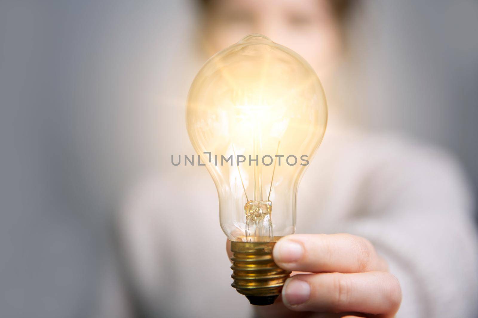 Female hand holding a shining light bulb, Great idea, innovation and inspiration, business concept background modern retro design