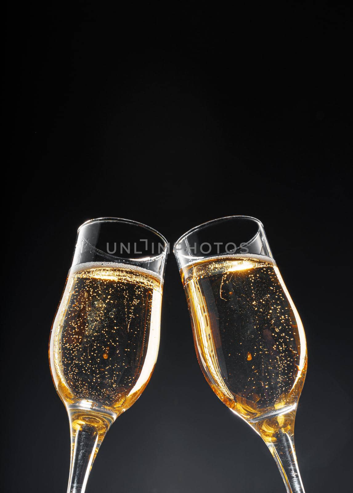 Glass full of champagne on black background, copy space