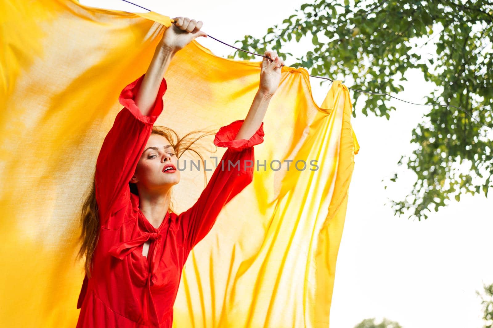 woman in red dress outdoors yellow bedspread. High quality photo