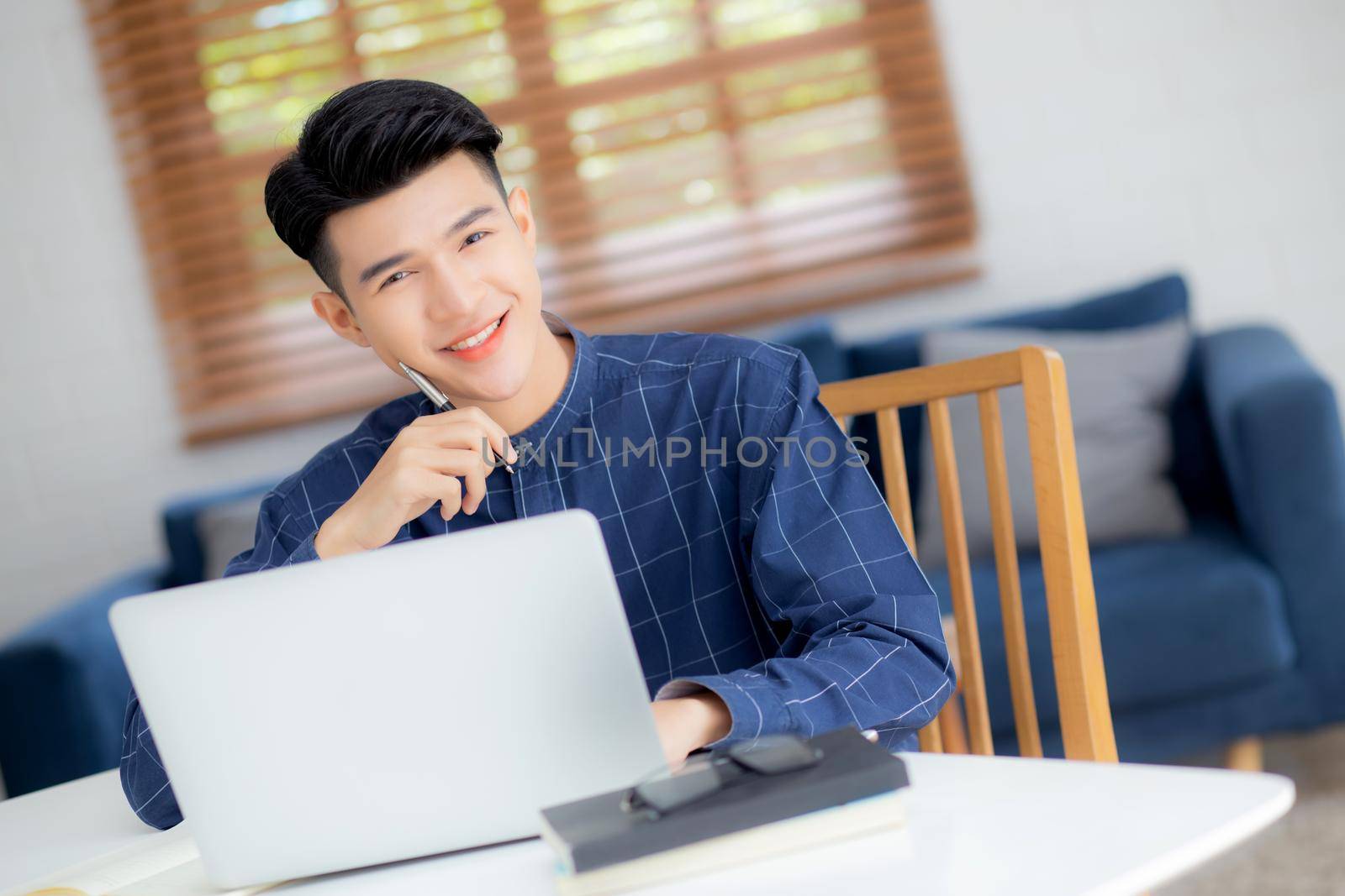 Young asian business man planning working and using laptop computer on desk at home, notes about finance, male study and learning, businessman thinking idea, business and communication concept. by nnudoo