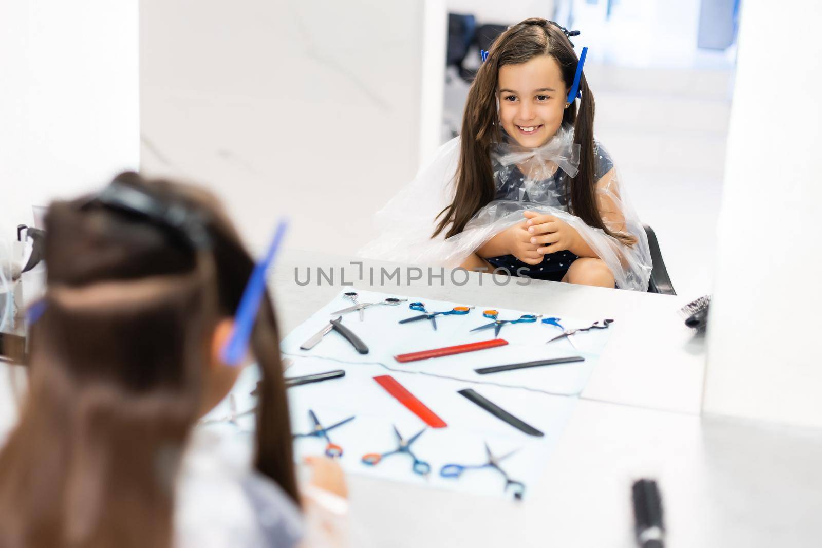 Pretty young girl's hair being arranged at the hair stylist