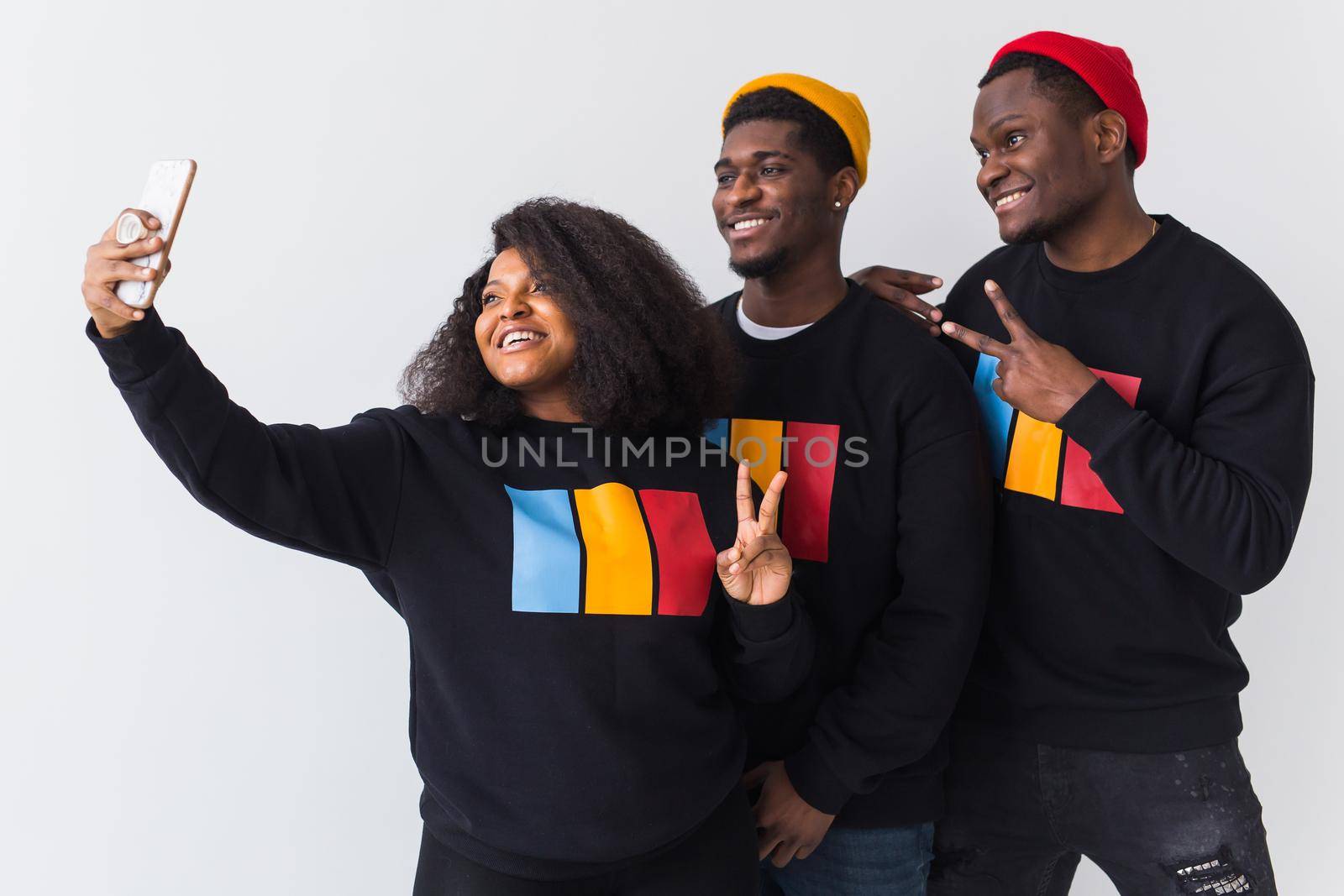 Friendship and fun concept - Group of friends afro american men and woman taking selfie in studio on white background