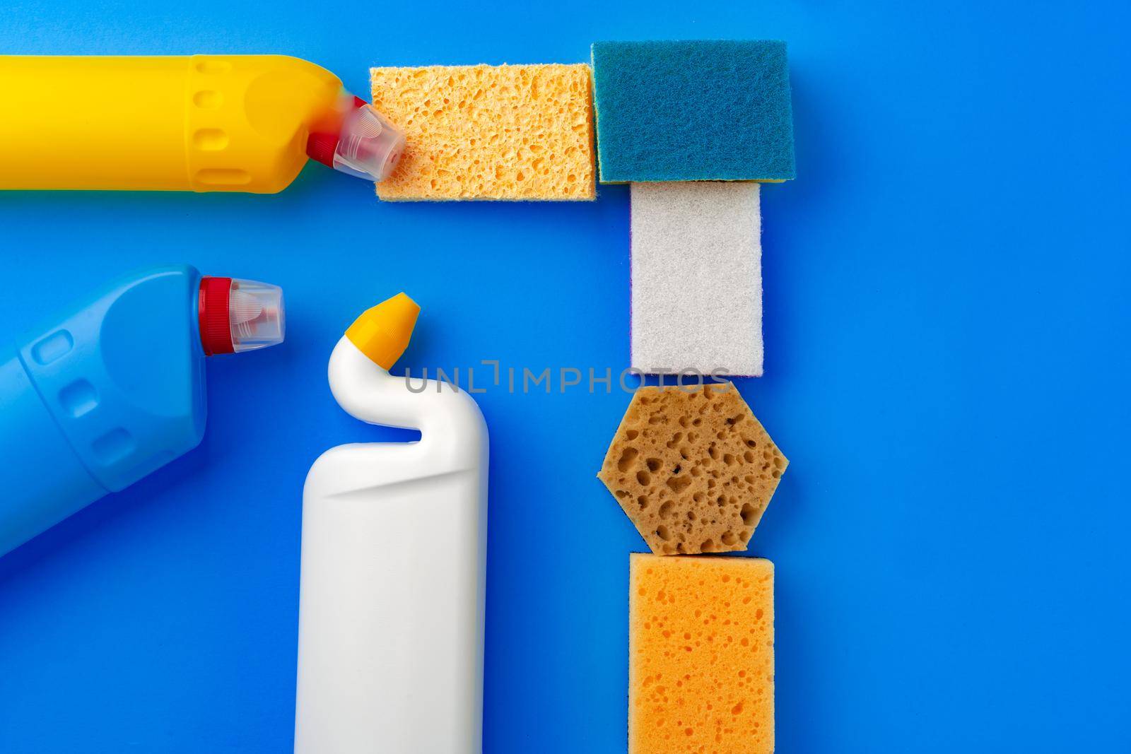 House cleaning supplies on blue color background, top view
