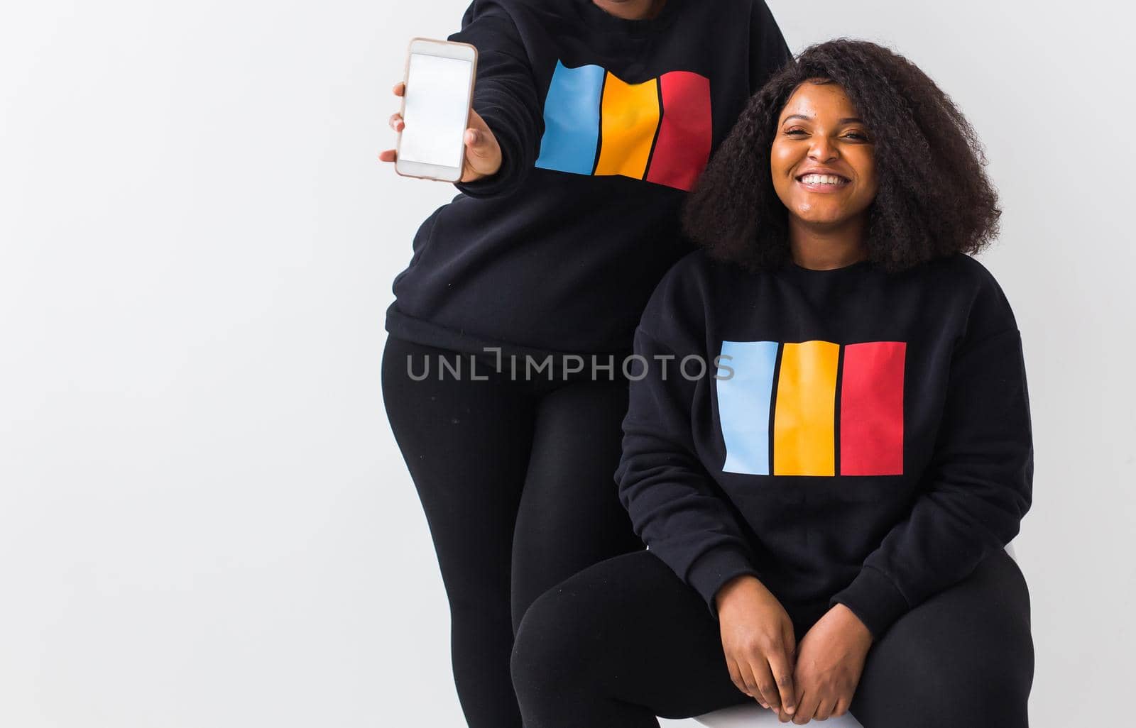 Happy African American women have relationships, toothy smile, happy to meet with friends, dressed casually on white background. Emotions and friendship concept