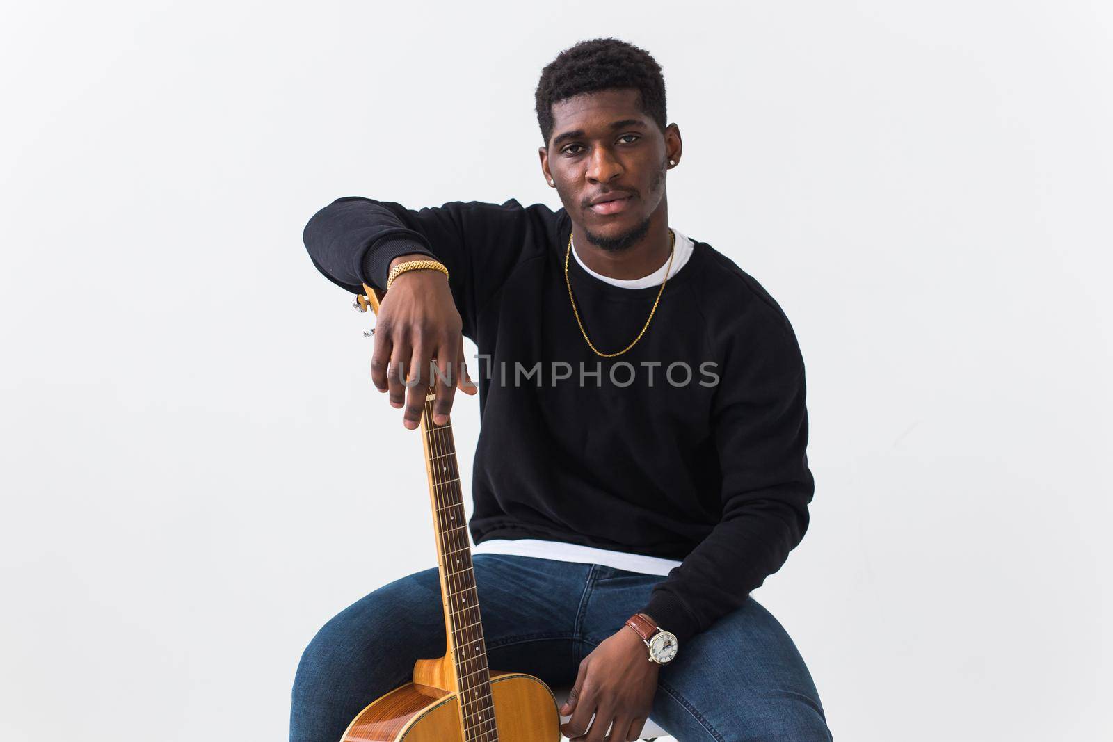 Studio shot of young handsome African man wearing hoodie against white background.