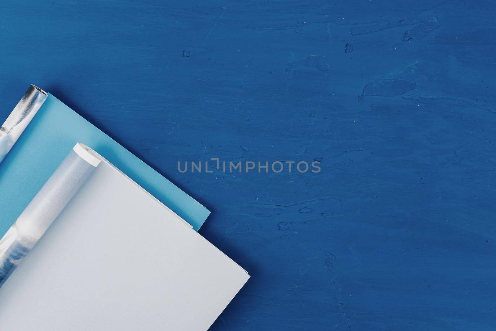 Top view of open magazine page with copy space on classic blue background. High quality photo