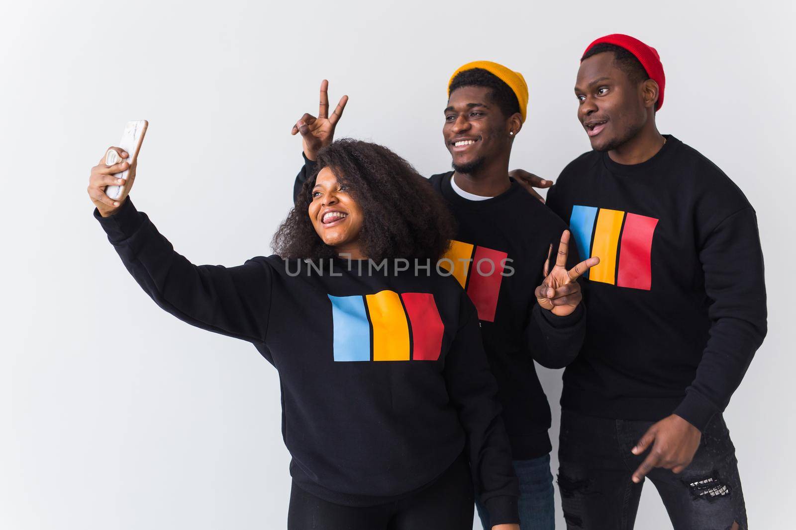 Friendship and fun concept - Group of friends afro american men and woman taking selfie in studio on white background