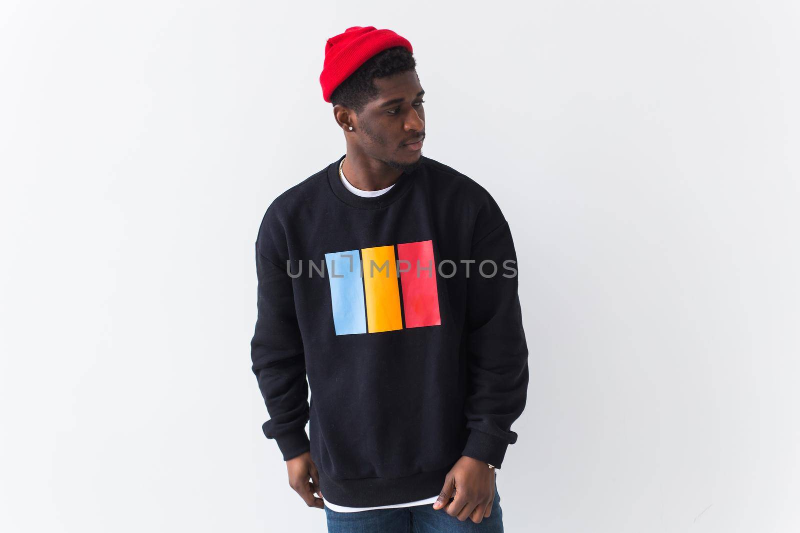 Handsome African American man posing in black hoodie on a white background. Youth street fashion photo with afro hairstyle