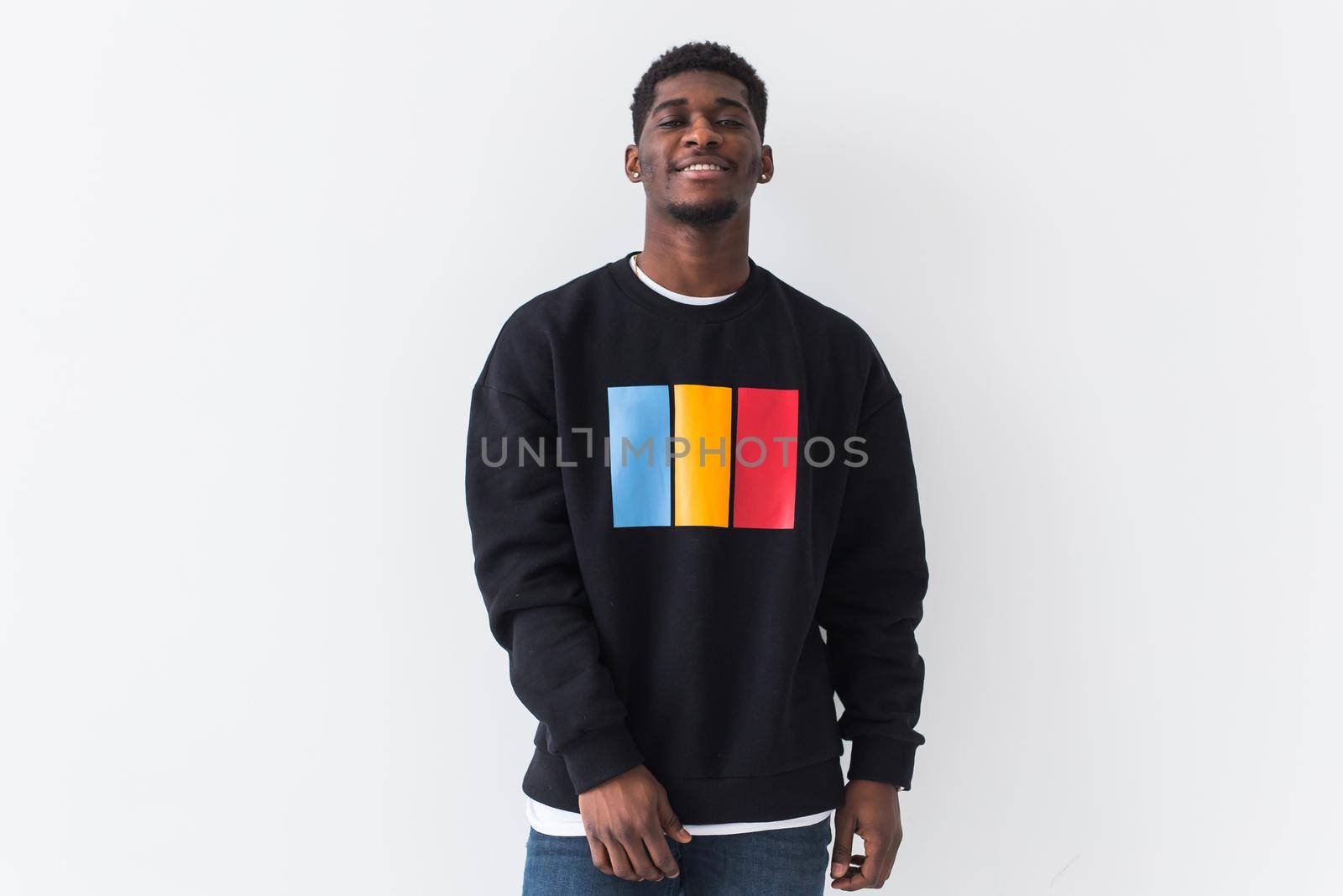 Portrait handsome young black man dressed in jeans and hoodie on white background. Street fashion and modern youth culture
