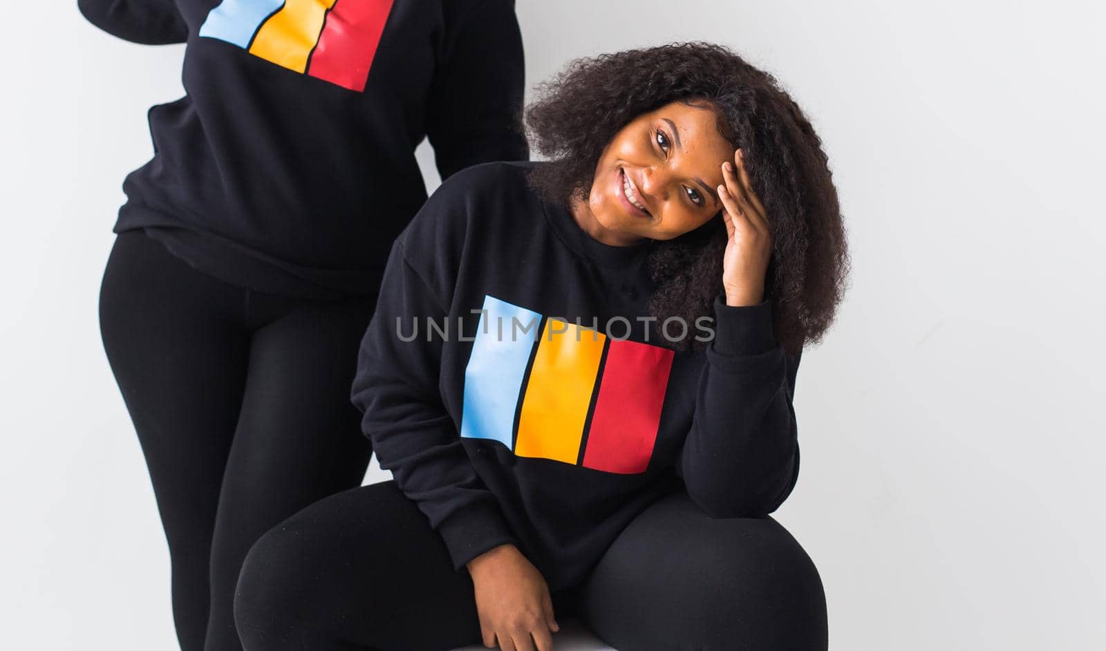 Happy African American women have relationships, toothy smile, happy to meet with friends, dressed casually on white background. Emotions and friendship concept