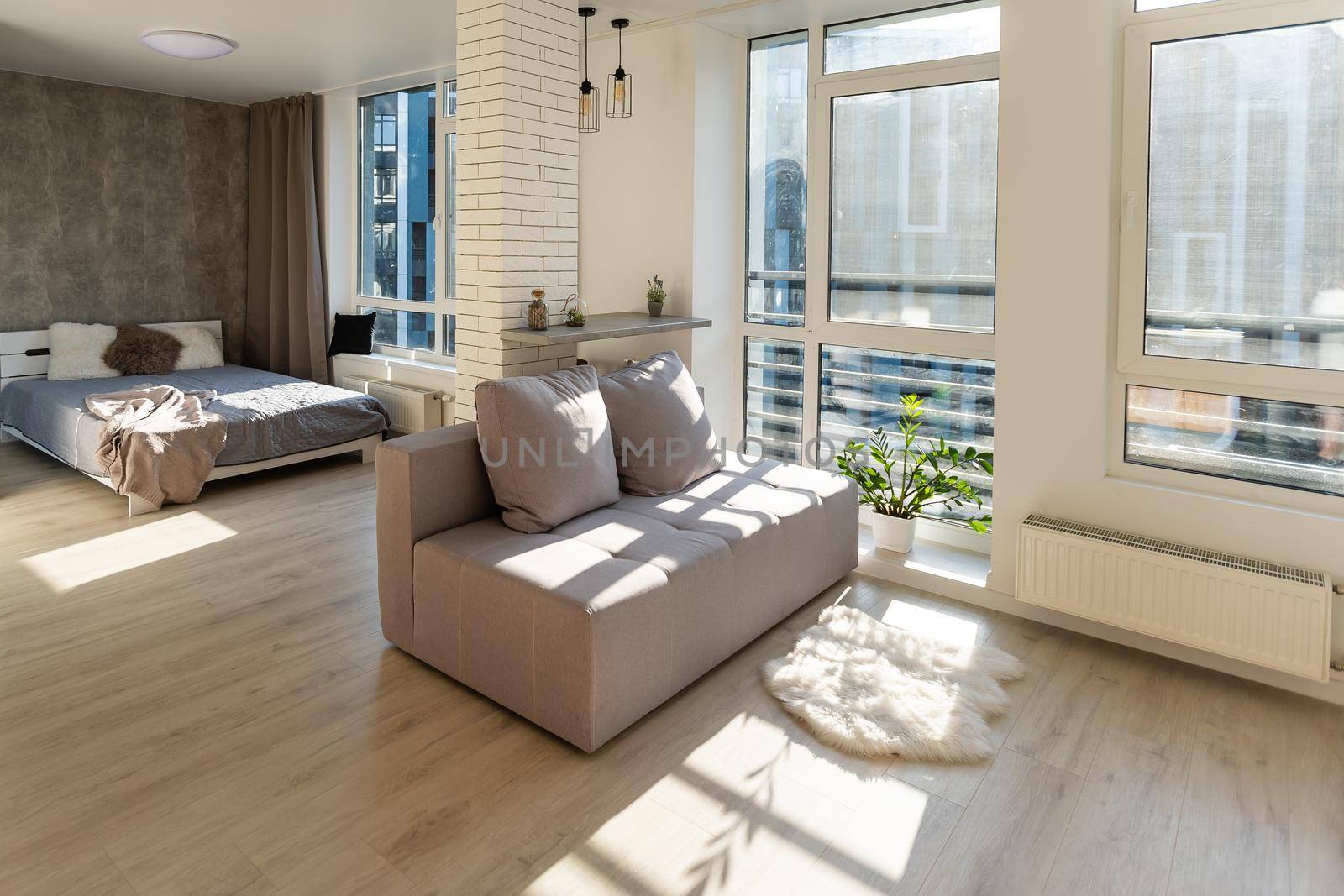 Interior of a studio apartment, wide room, bed in the foreground