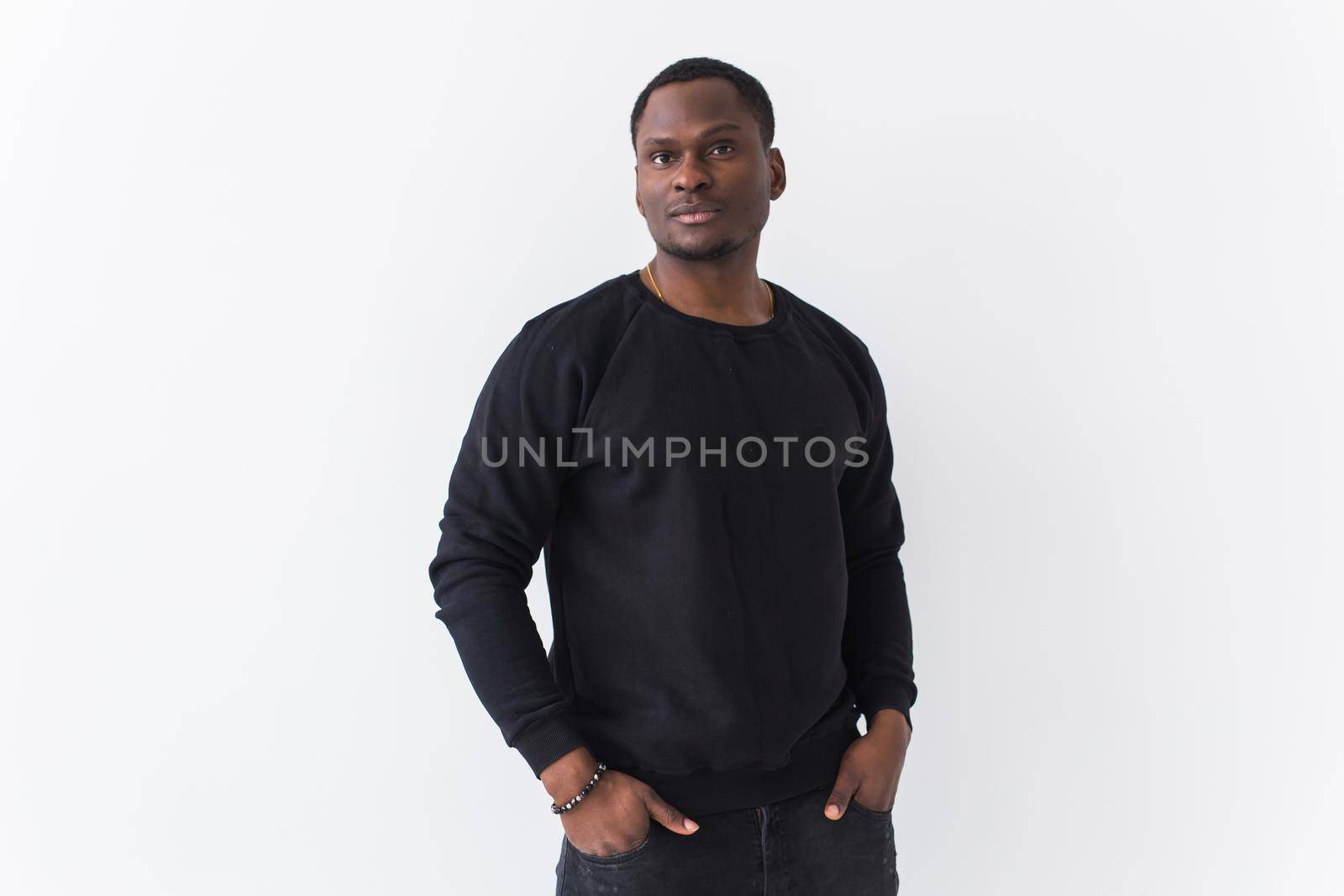 Portrait handsome young black man dressed in jeans and hoodie on white background. Street fashion and modern youth culture