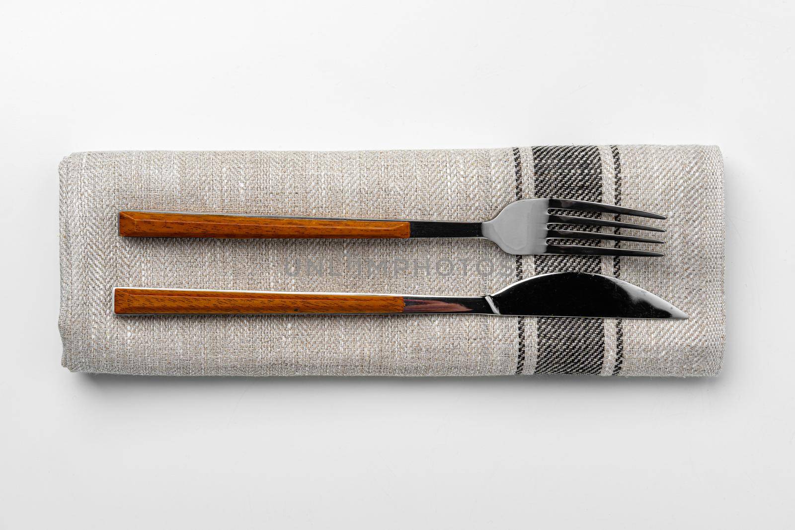 Set of fork and knife on towel. Isolated on white background. Close up.