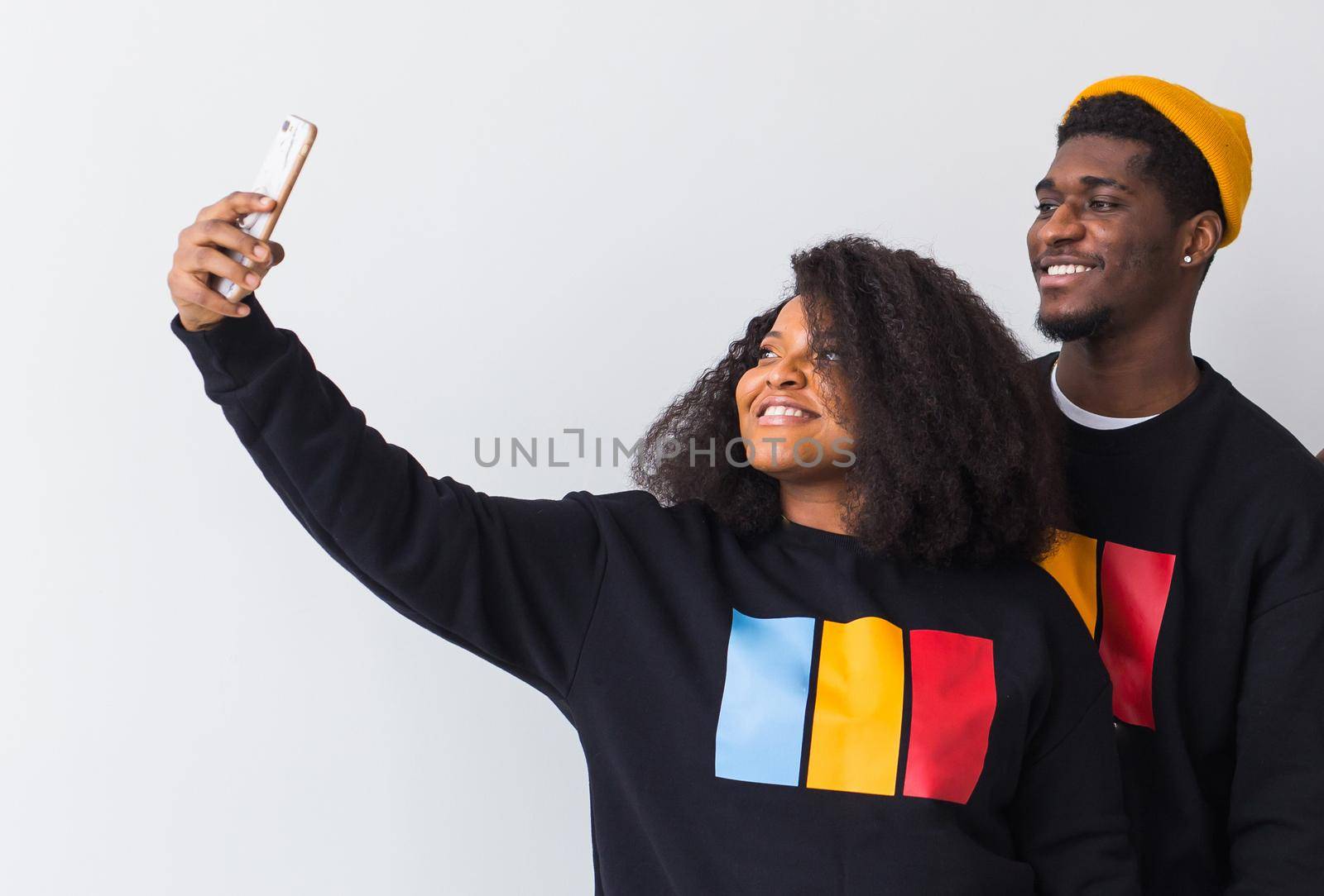 Friendship and fun concept - Group of friends afro american men and woman taking selfie in studio on white background
