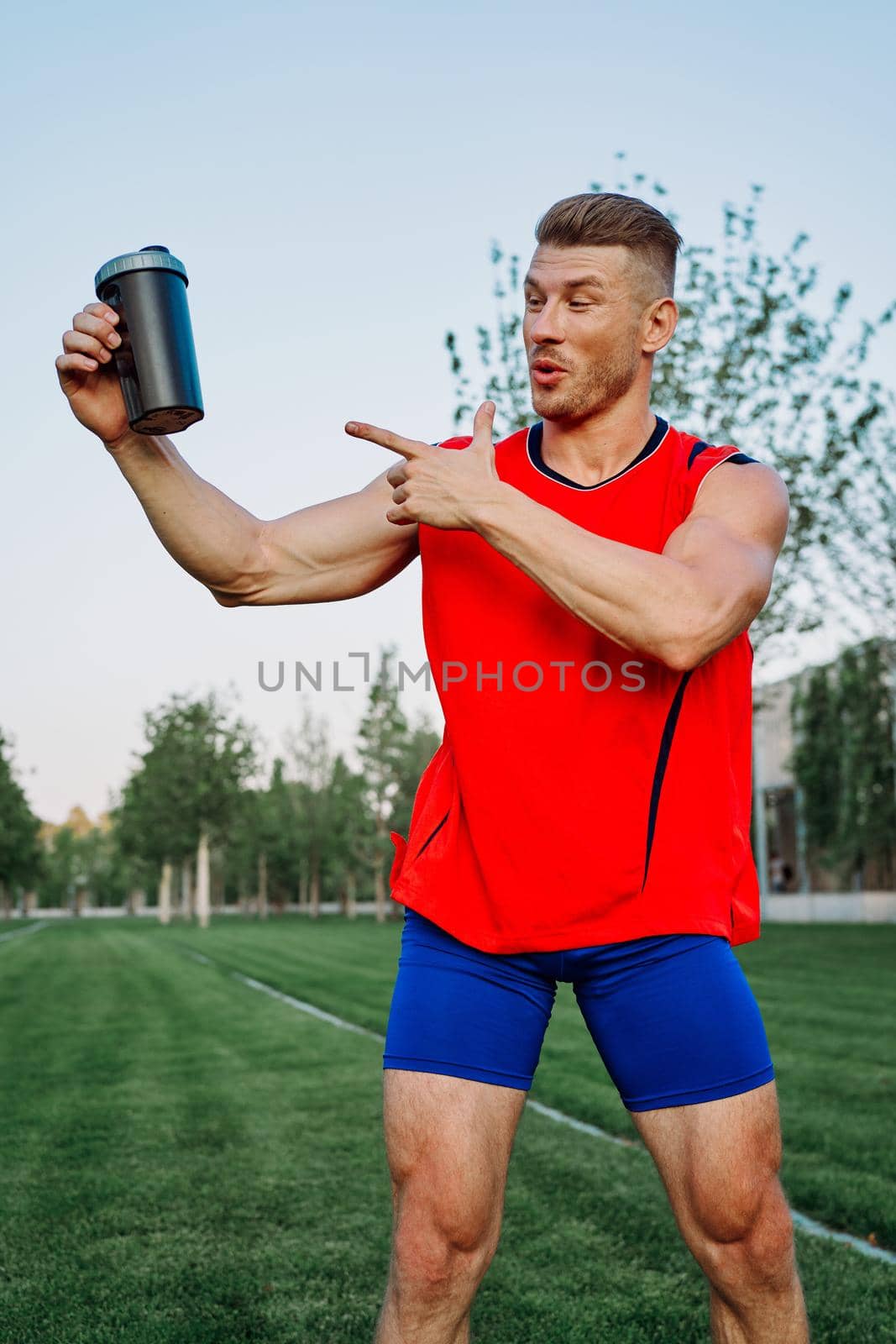 sporty man in the park outdoors glass with drink by Vichizh