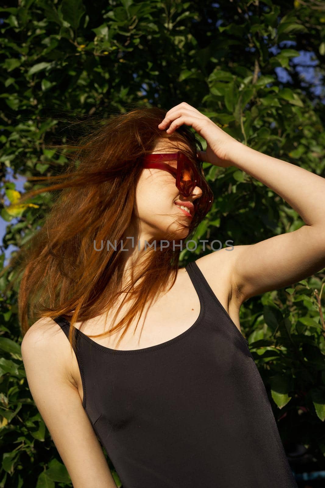 pretty woman wearing sunglasses green leaves summer model. High quality photo