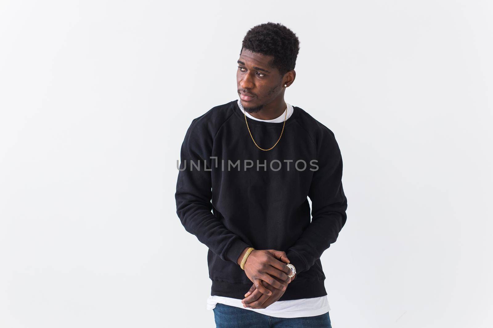 Studio shot of young handsome African man wearing hoodie against white background.