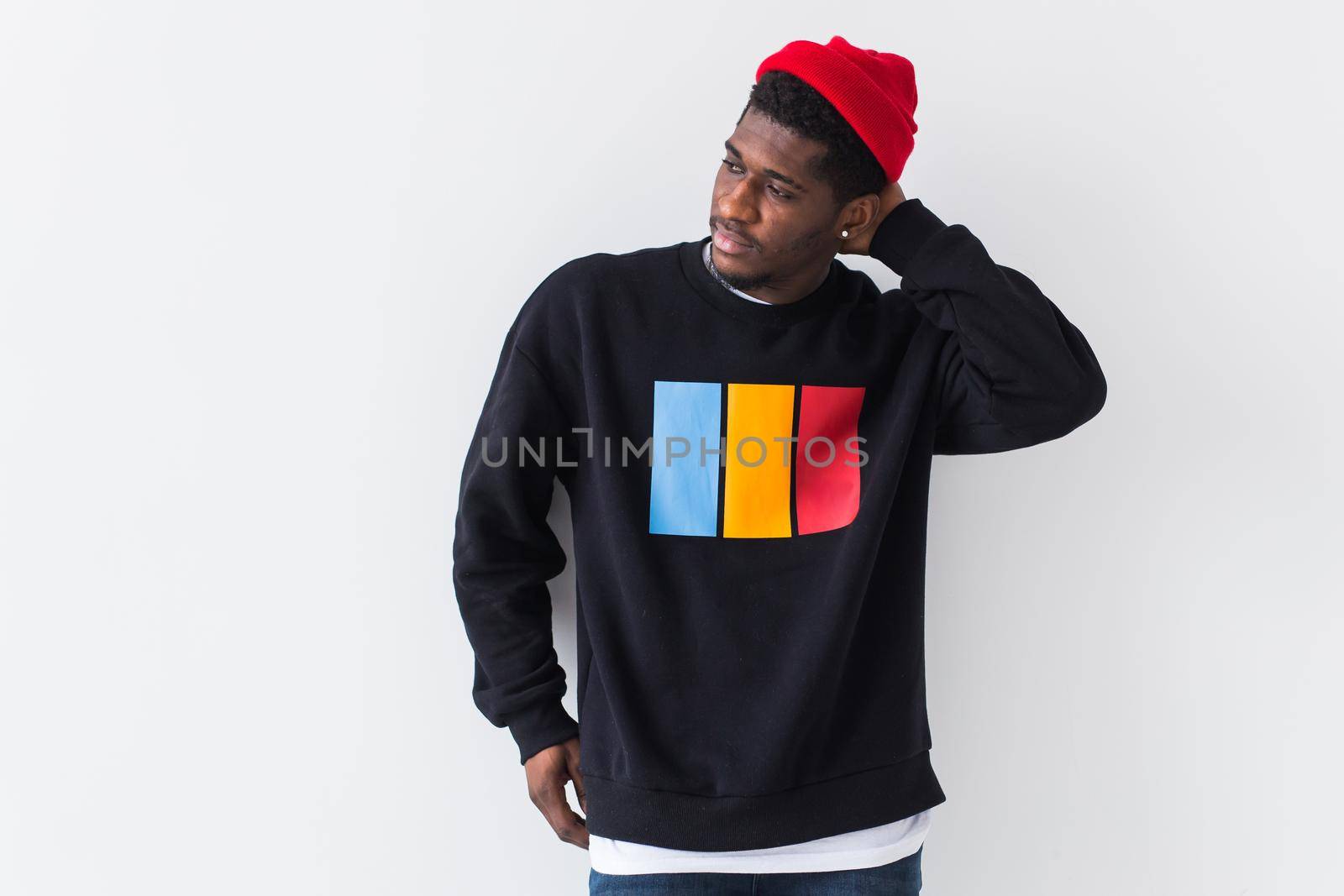 Studio shot of young handsome African man wearing hoodie against white background.