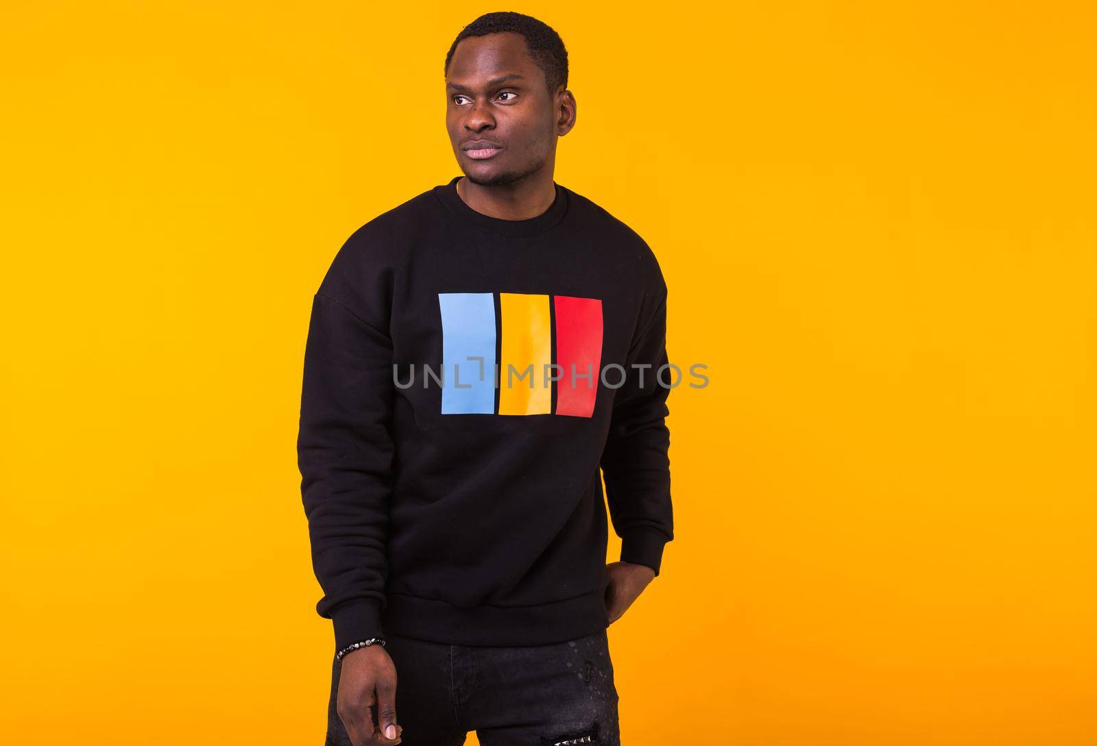 Portrait handsome young black man dressed in jeans and hoodie on white background. Street fashion and modern youth culture