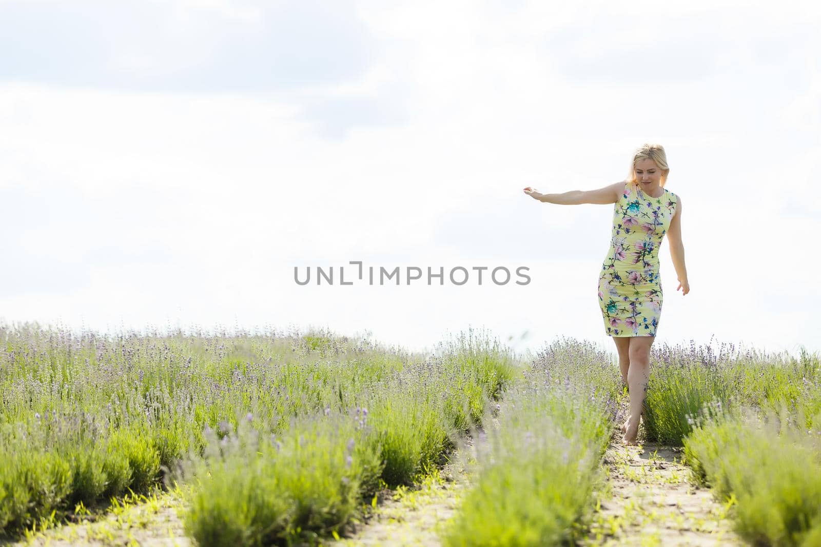 Woman standing with open arms on a lavender field