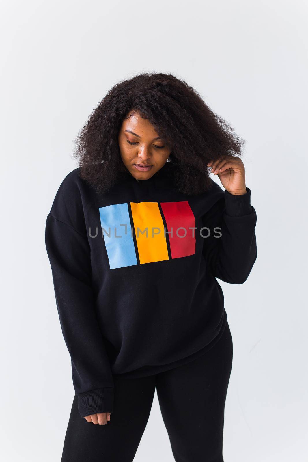 Youth street fashion concept - Portrait of confident sexy black woman in stylish sweatshirt on white background. by Satura86