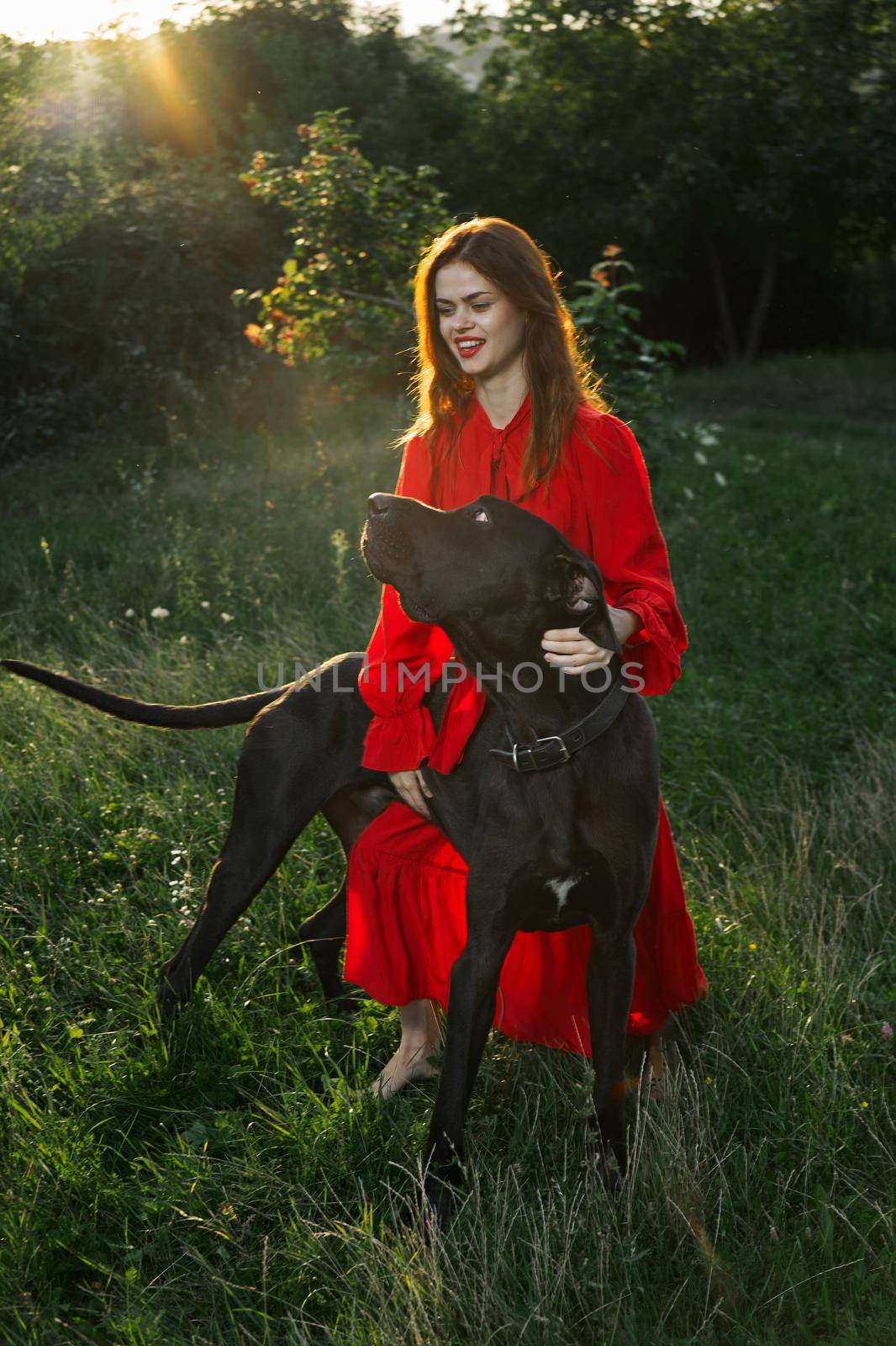 woman in a red dress in a field with a black dog Friendship fun by Vichizh