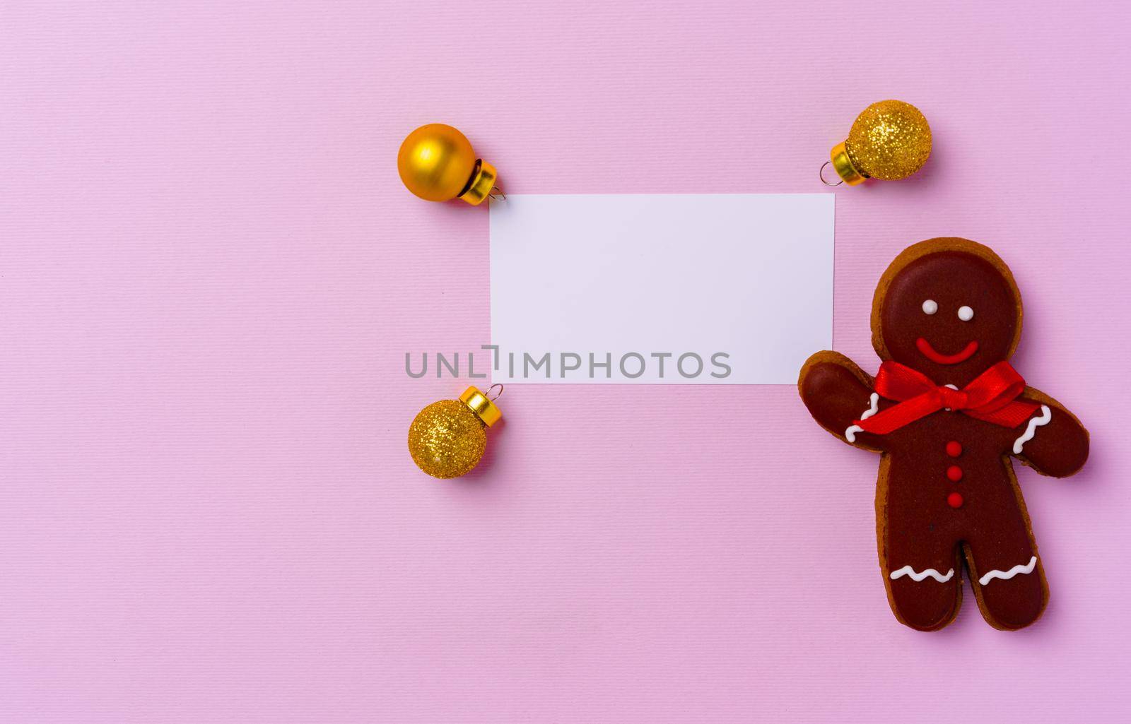 Mock up of holiday greeting card with gingerbread cookies on pink background, view from above