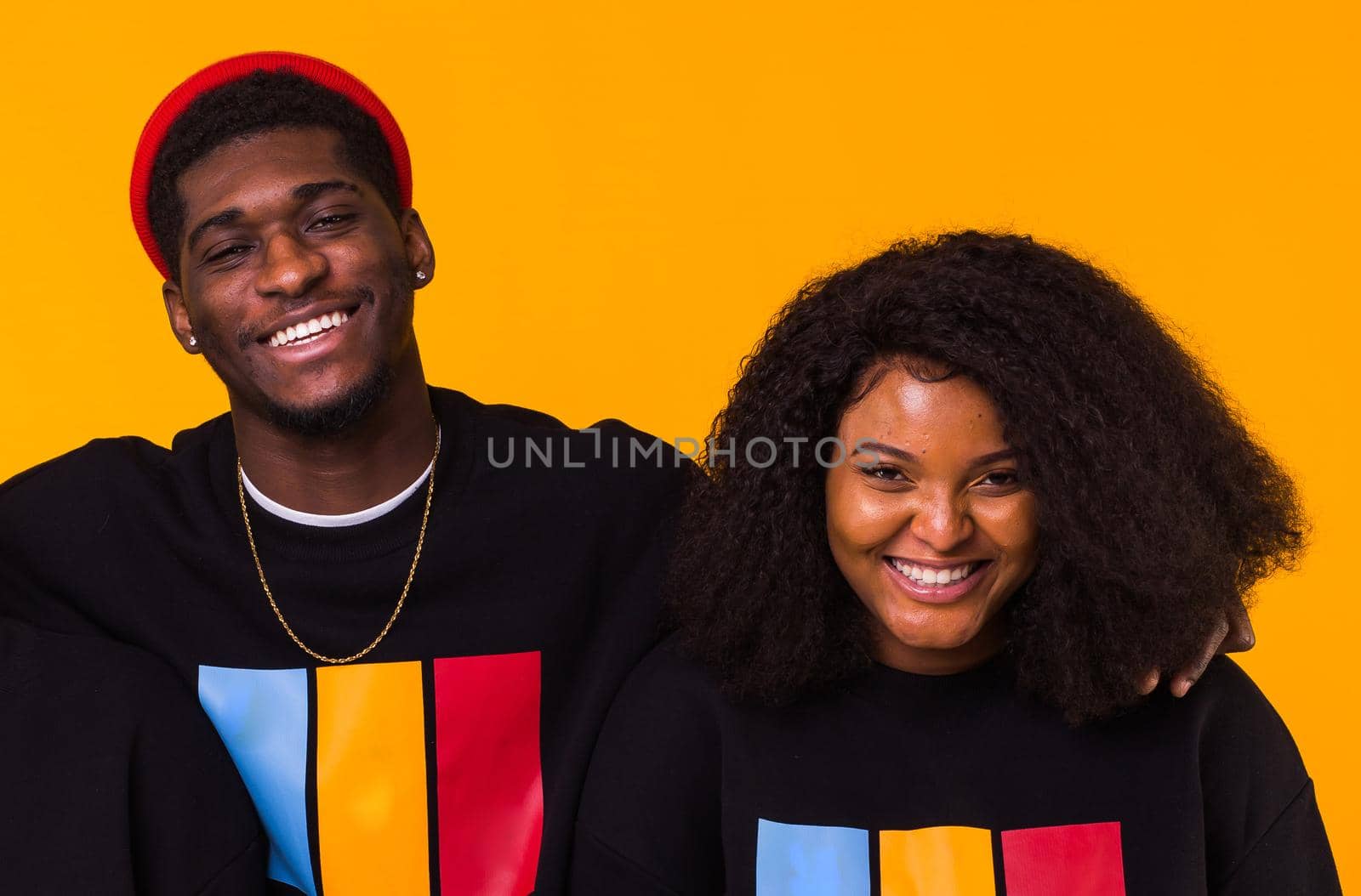 Happy African American woman and man have relationships, toothy smile, happy to meet with friends, dressed casually on yellow background. Emotions and friendship concept. by Satura86