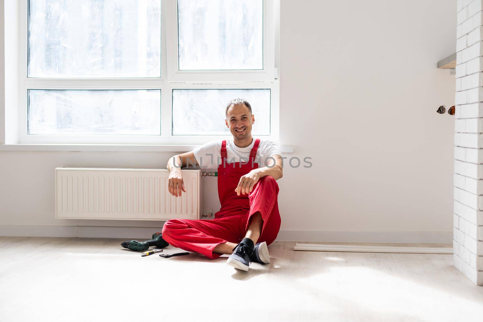 Portrait of joyful cheerful repairer having equipment in the apartment