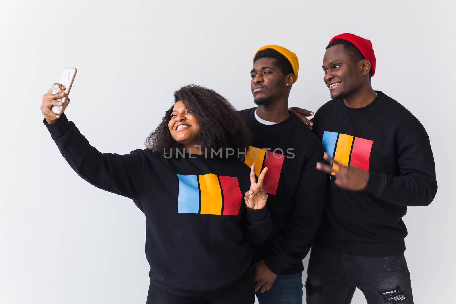 Friendship and fun concept - Group of friends afro american men and woman taking selfie in studio on white background. by Satura86