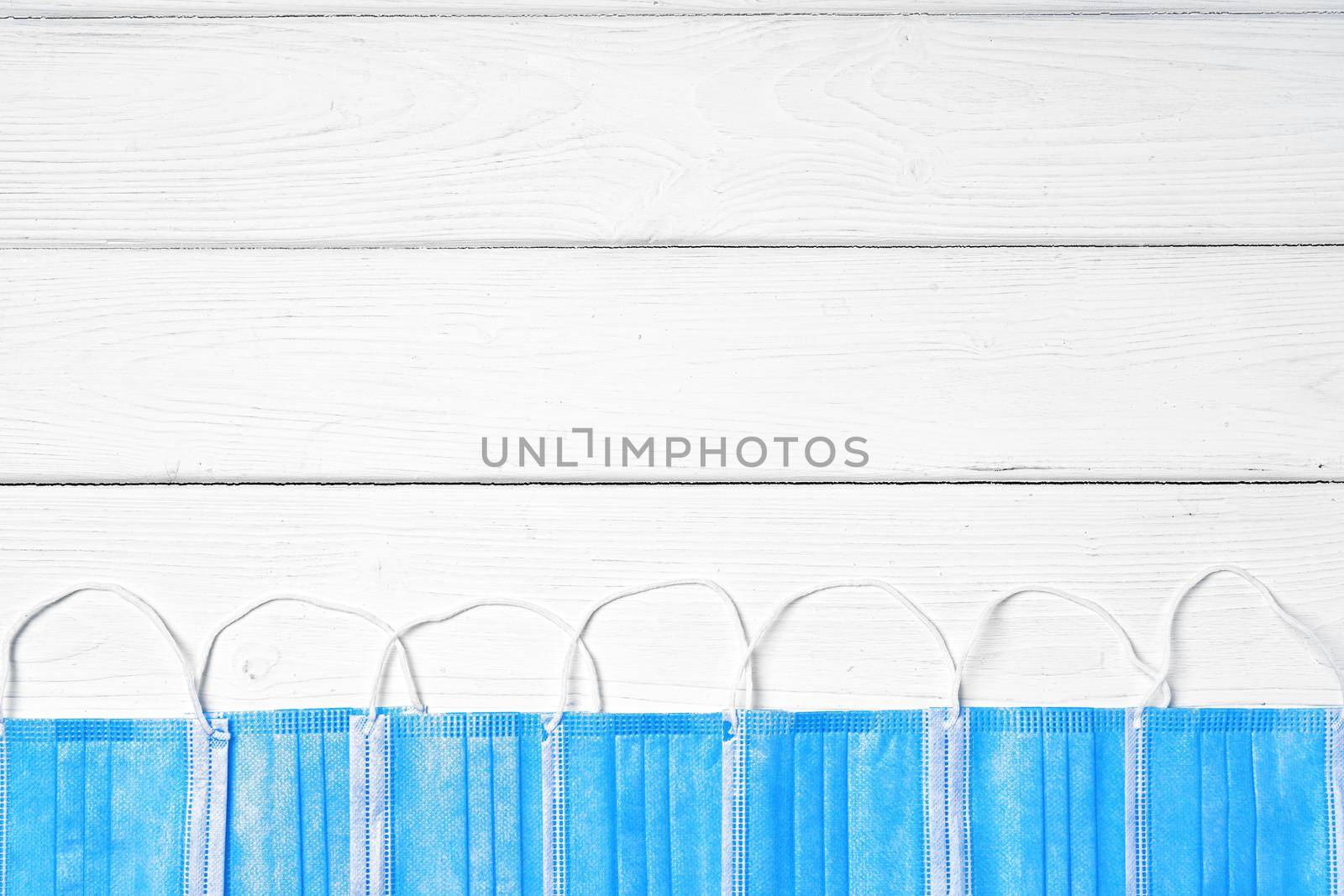 Blue medical face masks on white wooden background