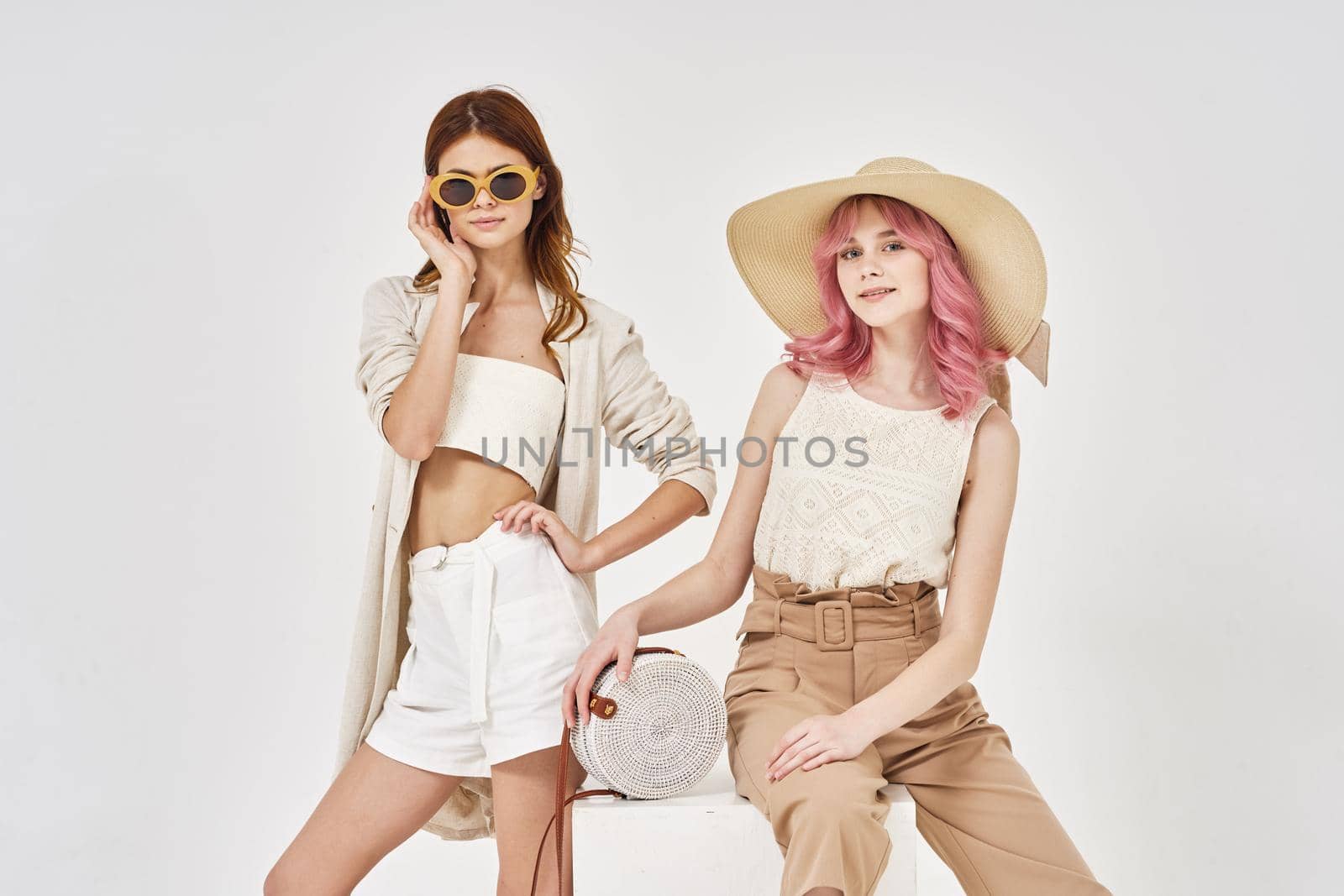 two girlfriends stand side by side fashion clothing glamor posing. High quality photo