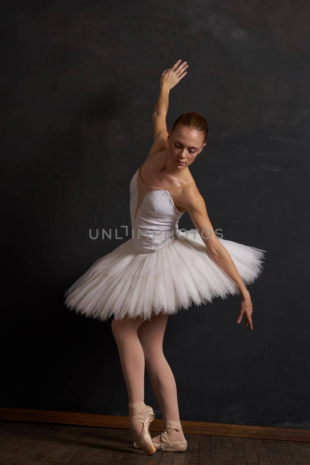 woman ballerina in a white tutu dance posing performance dark background by Vichizh