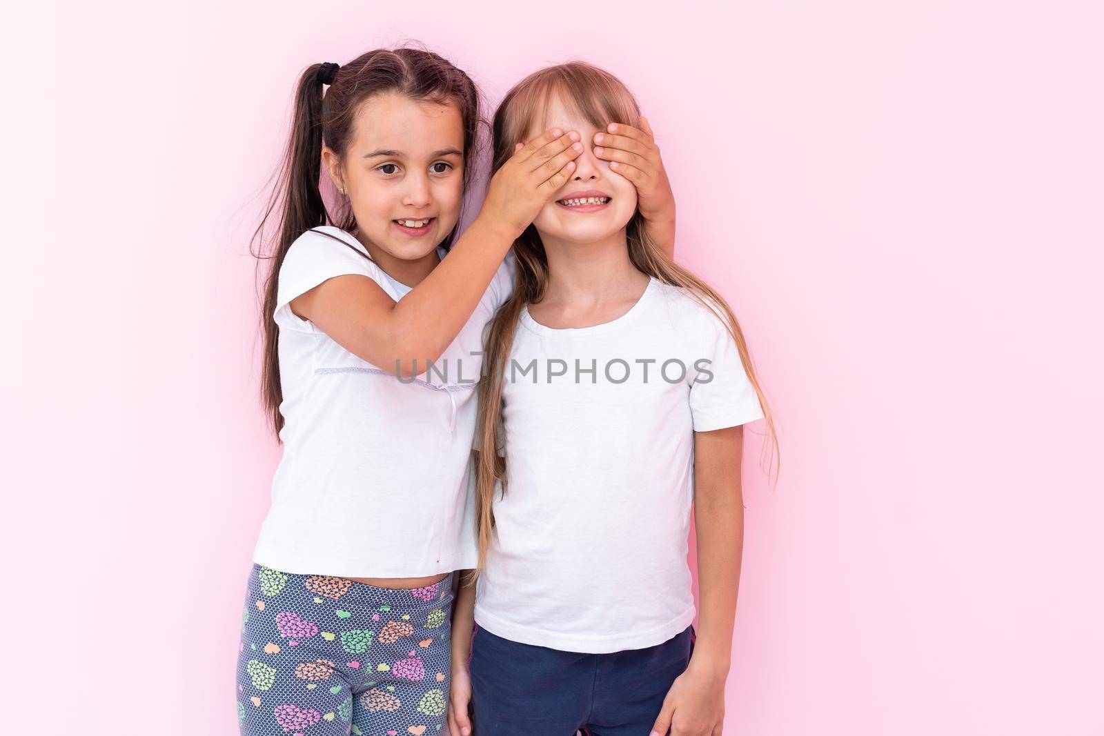 two little girls closing eyes making surprise, excited child by Andelov13