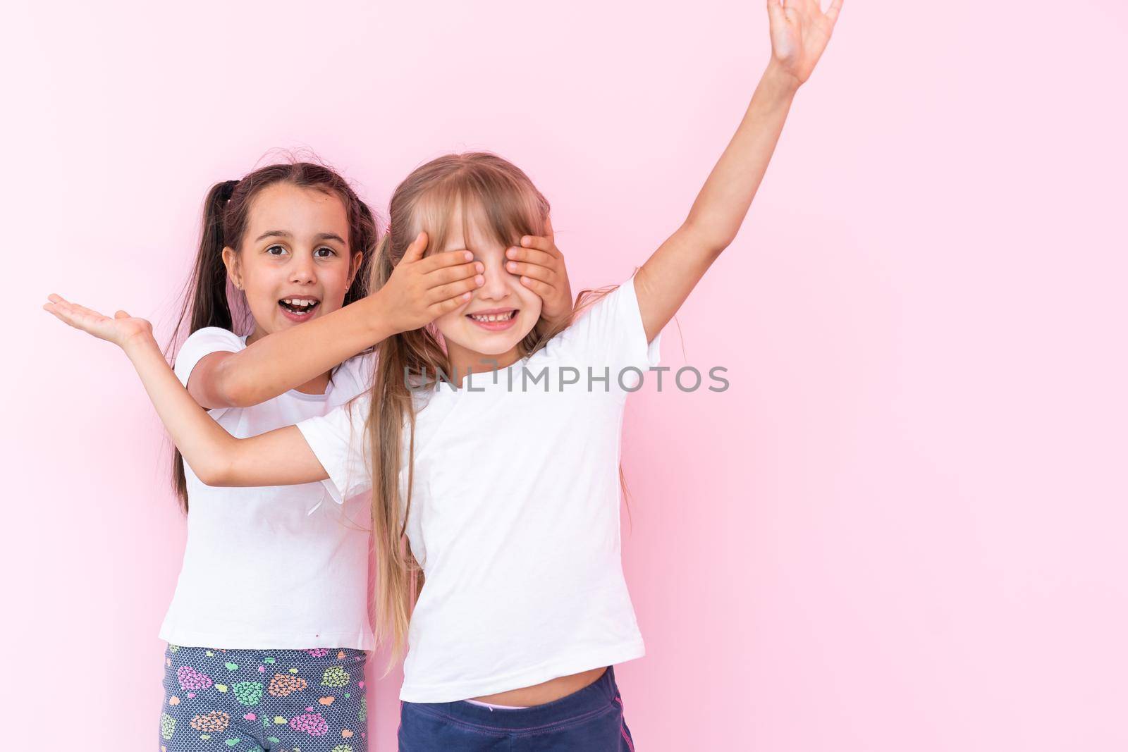 two little girls closing eyes making surprise, excited child by Andelov13